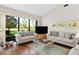 Bright living room with hardwood floors, comfortable seating, and large window overlooking the lush outdoor scenery at 5336 Huntingwood Ct # 24, Sarasota, FL 34235