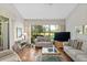 Bright living room with hardwood floors, comfortable seating, and large window overlooking the lush outdoor scenery at 5336 Huntingwood Ct # 24, Sarasota, FL 34235