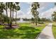 Peaceful pond with a water fountain and scenic walking path surrounded by lush landscaping at 5336 Huntingwood Ct # 24, Sarasota, FL 34235