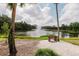 Scenic pond view with fountain, surrounded by palm trees and green landscaping with a bench at 5336 Huntingwood Ct # 24, Sarasota, FL 34235