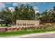 Entrance sign to The Meadows community with beautiful stone wall and landscaping at 5336 Huntingwood Ct # 24, Sarasota, FL 34235