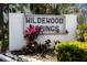Welcoming community entrance sign 'Wildewood Springs' with colorful plants and greenery at 536 Lakeside Dr # 536, Bradenton, FL 34210