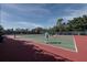 Outdoor tennis court with players in action, surrounded by lush green foliage and a blue sky at 536 Lakeside Dr # 0, Bradenton, FL 34210