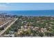 Stunning aerial view of a residential neighborhood nestled among lush trees, with a clear ocean backdrop at 6304 Pelican Dr, Bradenton, FL 34210