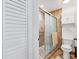 Bathroom with a tiled shower, sliding glass door, toilet, and white cabinet on the wall at 6304 Pelican Dr, Bradenton, FL 34210