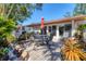 Serene private courtyard with brick-paved patio, seating, and lush tropical landscaping at 6304 Pelican Dr, Bradenton, FL 34210
