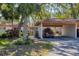 Exterior view of the property with carport, showcasing the tropical landscaping and well-maintained surroundings at 6304 Pelican Dr, Bradenton, FL 34210