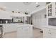 Open kitchen with white cabinets, stainless steel refrigerator, and island creating an ideal space for cooking and entertaining at 6304 Pelican Dr, Bradenton, FL 34210