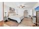 Bright main bedroom with an en suite bathroom featuring a ceiling fan and a beach themed painting at 6304 Pelican Dr, Bradenton, FL 34210