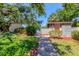 Charming pathway leading to the community pool area, bordered by colorful plants and mature trees at 6304 Pelican Dr, Bradenton, FL 34210