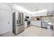 Spacious kitchen with stainless steel appliances and white cabinetry and adjacent living space at 6405 99Th E St, Bradenton, FL 34202