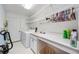 Functional laundry room with washer, dryer, sink, storage, and cleaning supplies at 6405 99Th E St, Bradenton, FL 34202