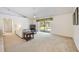 Spacious living room featuring a vaulted ceiling, neutral carpet, and sliding glass doors to the patio at 6405 99Th E St, Bradenton, FL 34202