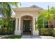 Inviting front entrance with columns, arched entryway, and lush tropical landscaping at 6415 67Th E St, Bradenton, FL 34203