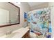 Bathroom featuring a modern vanity with a decorative mirror and a surf-themed shower curtain at 6546 Blue Grosbeak Cir, Lakewood Ranch, FL 34202