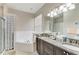 Bathroom featuring a double vanity with granite countertops, a jetted tub, and a separate glass-enclosed shower at 6546 Blue Grosbeak Cir, Lakewood Ranch, FL 34202