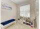 Bright bedroom featuring a charming display shelf, a cushioned bench, and a large window for natural light at 6546 Blue Grosbeak Cir, Lakewood Ranch, FL 34202