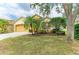 Landscaped lawn of single-story house, with attached 2-car garage and beautiful green trees at 6546 Blue Grosbeak Cir, Lakewood Ranch, FL 34202