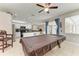 Open floor plan with a billiards room, dining area, and modern kitchen with white cabinets and stainless steel appliances at 6546 Blue Grosbeak Cir, Lakewood Ranch, FL 34202