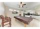 Billiards room with a covered pool table, comfortable seating, and an open view of the modern kitchen at 6546 Blue Grosbeak Cir, Lakewood Ranch, FL 34202