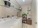 Laundry room with washer, dryer, and shelving for storage, and a tan tiled floor at 6546 Blue Grosbeak Cir, Lakewood Ranch, FL 34202