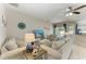 Comfortable living room features a ceiling fan and a sliding glass door to the outdoor pool area at 6546 Blue Grosbeak Cir, Lakewood Ranch, FL 34202