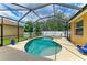 Screened-in pool area featuring a kidney-shaped pool and hot tub surrounded by ample patio space and privacy fence at 6546 Blue Grosbeak Cir, Lakewood Ranch, FL 34202