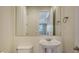 Cozy bathroom featuring a pedestal sink, large mirror, and convenient towel rack at 6931 Brier Creek Ct, Lakewood Ranch, FL 34202