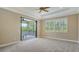 Light-filled bedroom with neutral carpet, tray ceiling, fan and access to screened lanai at 6931 Brier Creek Ct, Lakewood Ranch, FL 34202