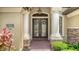 Charming double front doors with glass inserts and decorative wreaths, flanked by elegant columns and brick accents at 6931 Brier Creek Ct, Lakewood Ranch, FL 34202