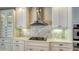 Stylish kitchen featuring white cabinets, stainless steel appliances, quartz countertops, and decorative backsplash at 6931 Brier Creek Ct, Lakewood Ranch, FL 34202