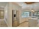 Modern kitchen showcasing stainless steel refrigerator, bright white cabinetry, countertops, and view of the screened-in pool at 6931 Brier Creek Ct, Lakewood Ranch, FL 34202