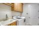 Efficient laundry room with front loading washer and dryer and extra cabinet storage above the units at 6931 Brier Creek Ct, Lakewood Ranch, FL 34202