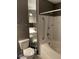 Toilet and shower with accessibility bar in neutral colored bathroom at 750 N Tamiami Trl # 208, Sarasota, FL 34236