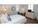 Bright bedroom with wood floors, white bedding, shutters, and stylish decor at 750 N Tamiami Trl # 208, Sarasota, FL 34236
