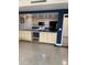 Bright kitchen with wood cabinets, modern appliances, and tile flooring at 750 N Tamiami Trl # 208, Sarasota, FL 34236
