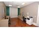 Community office space with multiple computer desks, wood floor, and natural lighting at 750 N Tamiami Trl # 208, Sarasota, FL 34236