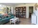 Comfortable living room with a teal sofa, built-in bookshelves, and large bright window at 91 39Th Street Nw Ct, Bradenton, FL 34205