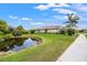 Beautiful backyard with a pond and a view of the home, along with the manicured lawn at 9774 Highland Park Pl, Palmetto, FL 34221