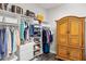 Walk-in closet features custom shelving, built-in drawers, hardwood floors and an armoire for extra storage at 9774 Highland Park Pl, Palmetto, FL 34221