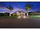 Beautiful home exterior at dusk with palm trees and a brick driveway, showcasing curb appeal at 9774 Highland Park Pl, Palmetto, FL 34221