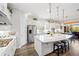 Open kitchen with stainless steel appliances, white cabinets, hardwood floors and a large island with bar seating at 9774 Highland Park Pl, Palmetto, FL 34221
