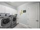 This is a spacious laundry room featuring a washer, dryer, and upper cabinets at 9774 Highland Park Pl, Palmetto, FL 34221