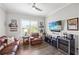 Cozy living room with plantation shutters, hardwood floors, comfortable seating and a wine fridge at 9774 Highland Park Pl, Palmetto, FL 34221