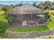 A relaxing screened-in porch with a tile patio, fire pit, and comfortable outdoor furniture overlooking a pond at 9774 Highland Park Pl, Palmetto, FL 34221