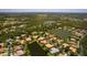 Property aerial in golf community featuring lake views, lush landscaping, tile roof and circular driveway at 11447 Savannah Lakes Dr, Parrish, FL 34219