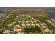 Aerial view shows the property in the community, next to a lake, golf course, lush landscaping and serene environment at 11447 Savannah Lakes Dr, Parrish, FL 34219