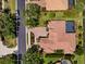 An overhead view of the property highlights the tile roof, screened lanai, lush landscaping and circular driveway at 11447 Savannah Lakes Dr, Parrish, FL 34219
