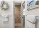 A modern bathroom with a tiled shower, decorative towels, and coastal-themed decorations at 11447 Savannah Lakes Dr, Parrish, FL 34219