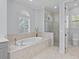 Bathroom featuring soaking tub, walk-in shower, and ample natural light at 11447 Savannah Lakes Dr, Parrish, FL 34219